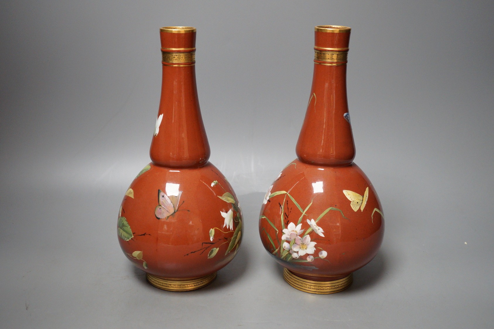 A pair of Mintons Aesthetic period enamelled pottery vases, c.1879, 26cm